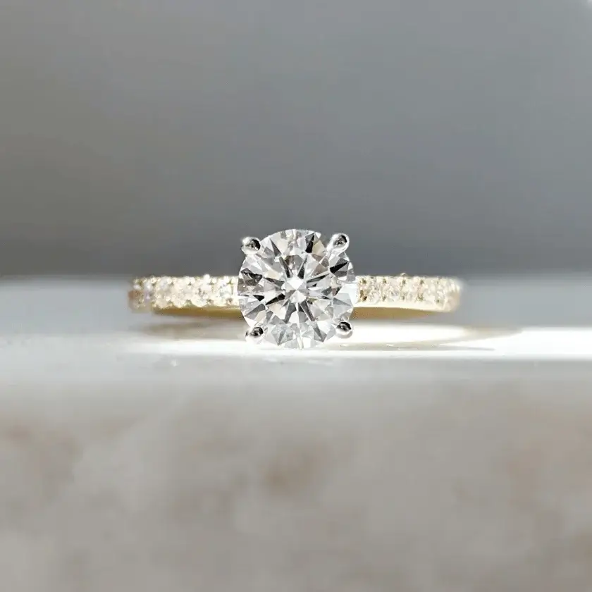 four prong solitaire engagement ring featuring round brilliant hearts and arrow diamonds